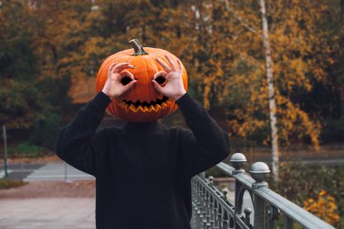Cadılar Bayramı. Balkabağı. Sabah şehrinin sokaklarında kafasında balkabağı olan bir adam.