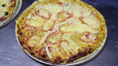 Close-up, smooth camera movement, selective focus, fresh pizza on the kitchen table of a restaurant, pizzeria.