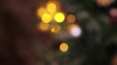 Odaklanma Bokeh 'ten sahte bir Noel ağacına yakın plan Noel oyuncaklarına kayıyor..
