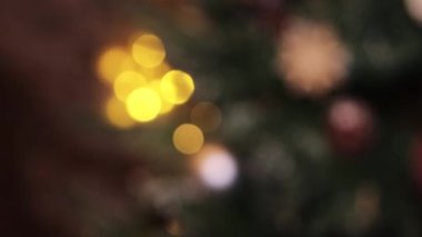 Odaklanma Bokeh 'ten sahte bir Noel ağacına yakın plan Noel oyuncaklarına kayıyor..