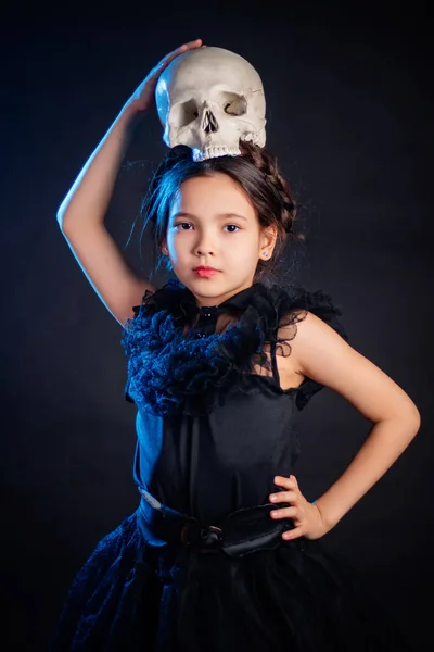 Маленька Дівчинка Чорній Сукні Зачіскою Косичками Голові Позує Черепом Руках — стокове фото