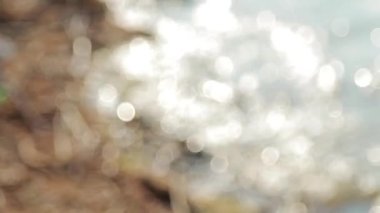 Pürüzsüz kamera hareketi, Bokeh 'ten nehir kıyısındaki dalgalara seçici odaklanma.