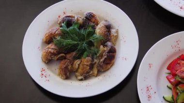 Pürüzsüz kamera hareketi, seçici odaklanma, siyah ahşap bir masada sebze salatalarıyla bir tabağın yakın çekimi..