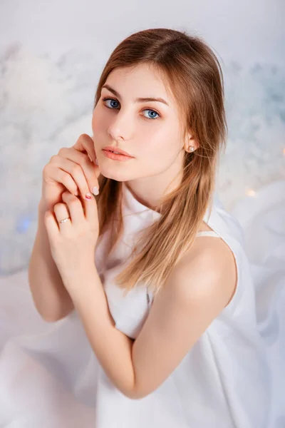 Retrato Uma Jovem Mulher Uma Túnica Branca Sentada Fundo Branco — Fotografia de Stock