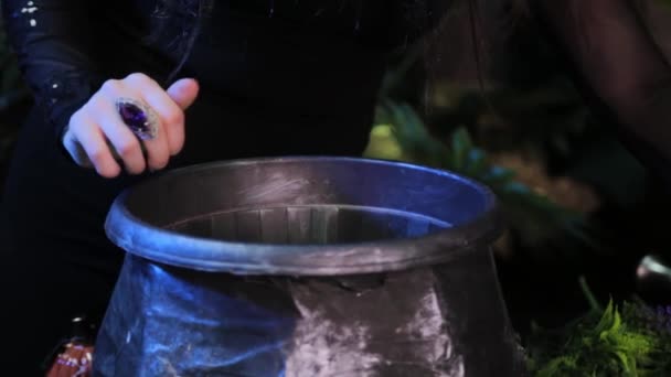 镜头平稳的移动 女巫的手的特写 用大锅施行巫术 — 图库视频影像