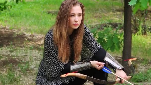 滑らかなカメラの動き 選択的な焦点 チェーンメールの若い女性 夏の森を背景に弓を手にしたブラジャー — ストック動画