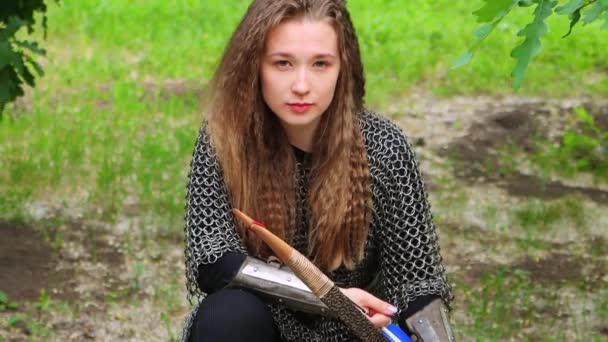 滑らかなカメラの動き 選択的な焦点 チェーンメールの若い女性 夏の森を背景に弓を手にしたブラジャー — ストック動画