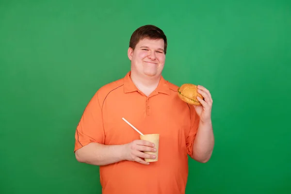 Büyük Bir Hamburger Yiyen Şişman Bir Adamın Portresi Yeşil Arka — Stok fotoğraf