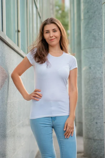 Una Joven Con Una Camiseta Blanca Posa Sobre Telón Fondo —  Fotos de Stock