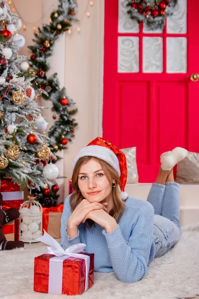 Egy Fiatal Vonzó Egy Ajándékkal Kezében Fekszik Egy Karácsonyfa Szilveszteri — Stock Fotó