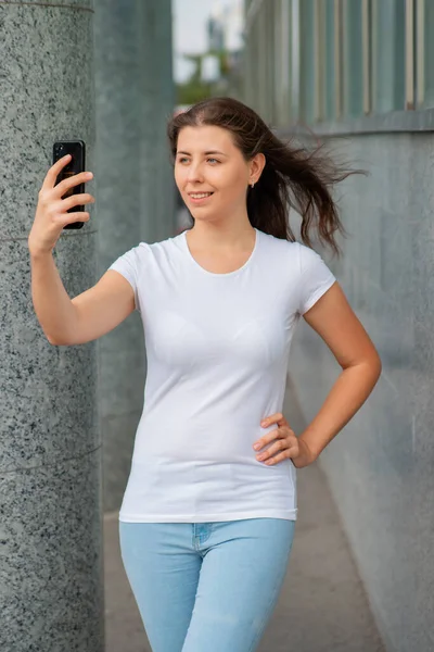 Retrato Uma Jovem Mulher Uma Camiseta Branca Com Smartphone Suas — Fotografia de Stock