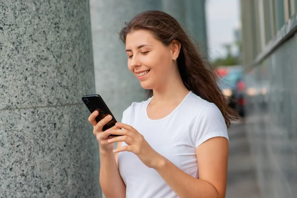 Retrato Uma Jovem Mulher Uma Camiseta Branca Com Smartphone Suas — Fotografia de Stock