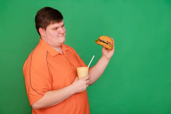 Portret Grubasa Jedzącego Wielkiego Hamburgera Pijącego Wodę Sodową Szklanki Słomką — Zdjęcie stockowe