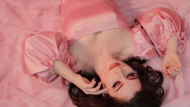 トップビュー 下に横たわっているピンクのドレスで若い女性のクローズアップ肖像画 — ストック動画