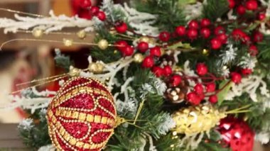 Dikey video, düz kamera hareketi, Noel oyuncaklarına yakın çekim, köknar dalları, dekorasyonlar, seçici odaklanma. Bokeh dolusu çelenk..