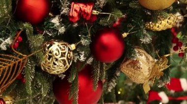 Dikey video, düz kamera hareketi, Noel oyuncaklarına yakın çekim, köknar dalları, dekorasyonlar, seçici odaklanma. Bokeh dolusu çelenk..