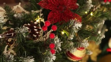 Dikey video, düz kamera hareketi, Noel oyuncaklarına yakın çekim, köknar dalları, dekorasyonlar, seçici odaklanma. Bokeh dolusu çelenk..