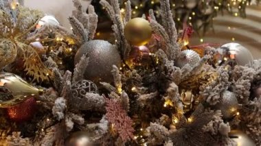 Dikey video, düz kamera hareketi, Noel oyuncaklarına yakın çekim, köknar dalları, dekorasyonlar, seçici odaklanma. Bokeh dolusu çelenk..