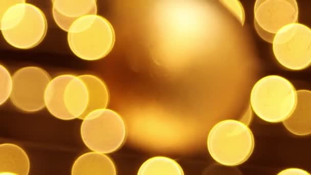 垂直录像 一个金色的圣诞球倒挂在一个花环的边缘 相机的运动 有选择的焦点 — 图库视频影像