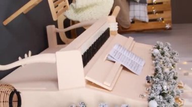 Dikey video, düz kamera hareketi, seçici odak, Noel dekorasyonlarına karşı piyano.