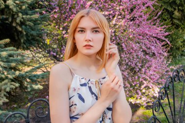 Sakura çiçeklerinin arka planında poz veren çekici bir kadının portresi..