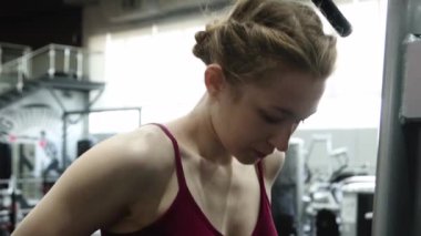 Spor salonundaki paralel barlara triseps daldırmak için egzersiz yapan genç atletik kadın, seçici odaklanma, kamera hareketi.