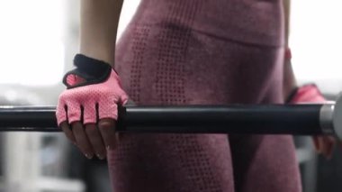 Spor salonundaki paralel barlara triseps daldırmak için egzersiz yapan genç atletik kadın, seçici odaklanma, kamera hareketi.