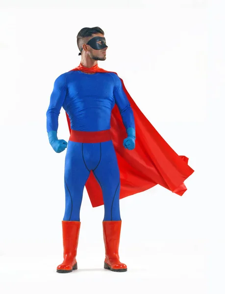Superhero wearing blue costume standing on white background.