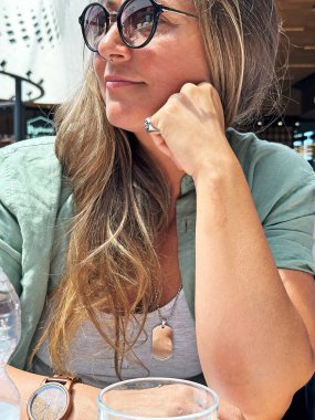 Bar masasındaki genç kadın rahat bir portre yaptırıyor..