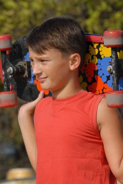 Kaykaycı çocuk şehir parkında kaykay yapıyor.