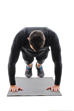  Spor salonu çalışanı beyaz arka planda spor salonu paspasında şınav çekiyor..