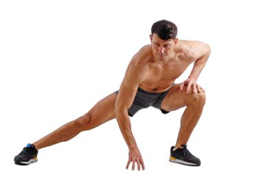 Beyaz arka planda esneyen gömleksiz fitness adamı..