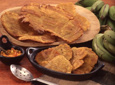 Tostones fritos en cocina rustica. clipart