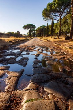sunset on ancient roman road of appian way clipart