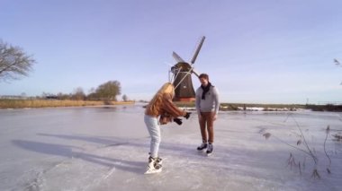 Sevgi dolu bir çift, tipik bir Hollanda yel değirmeni manzarasında buzda eğleniyor. Güneşli bir günde kadın ve erkek dışarıda buz pateni yapıyor. Noel arifesinde dondurucu kanalda romantik bir tarih.