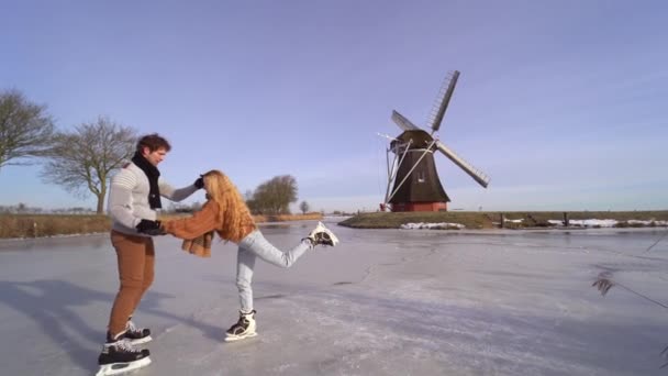 Casal Amoroso Divertindo Gelo Paisagem Típica Holandesa Com Moinho Vento — Vídeo de Stock