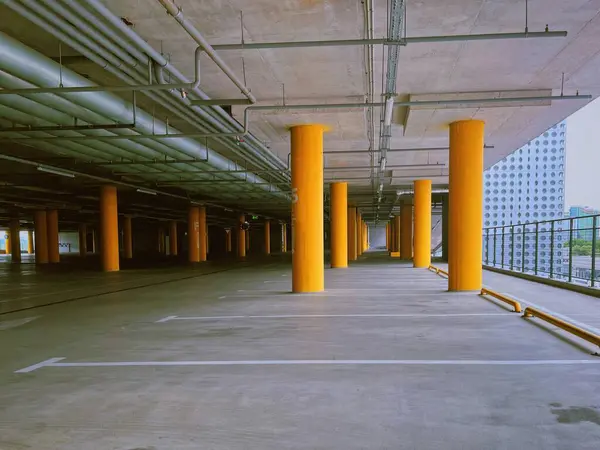 stock image Modern Parking Structure. An empty, well-designed parking lot with vibrant yellow pillars and industrial elements.