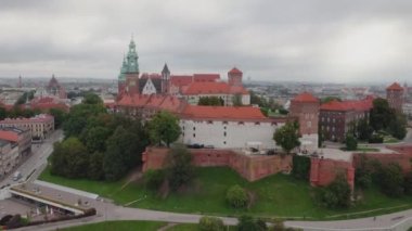 Wawel Tepesi 'nin havadan görünüşü, Royal Wawel Kalesi, kuleler ve katedral, Vistula nehri, arka plan - soldaki eski kasaba, Krakow şehri. Krakow, Polonya, Eylül 2022. Bulutlu bir gün. İleri uç..