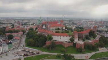 Wawel Tepesi 'nin havadan görünüşü, Royal Wawel Kalesi, kuleler ve katedral, Vistula nehri, soldaki Old Town, Krakow şehri. Krakow, Polonya, Eylül 2022. Bulutlu bir gün. İniş yapan ileri uçuş.