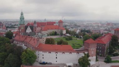 Wawel Tepesi 'nin havadan görünüşü, Royal Wawel Kalesi, kuleler ve katedral, Vistula nehri, soldaki Old Town, Krakow şehri. Krakow, Polonya, Eylül 2022. Bulutlu bir gün. Yörüngede yörüngede uçan atış.