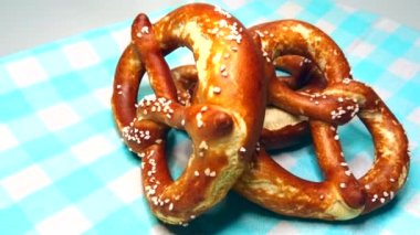 Three appetizing bavarian pretzel on blue cloth, rotating video