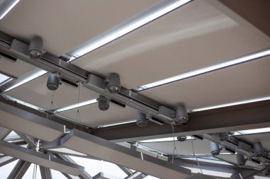 Motorized pleated blinds on the roof windows. Cellular blinds for skylights, beige color. Honeycomb curtains on glass roof. Selective focus.