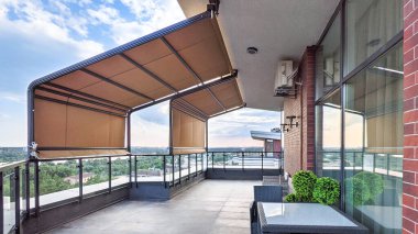 Awning 'ler terasta. En üst kattaki çatı katında bir teras ve muhteşem orman manzarası var..