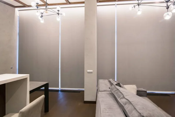 İçerde paten jaluzileri var. Tam boy pencerelerde otomatik karartma gölgeleri. Camdan duvarlı modern bir iç mekan. Pastel renkli iç döşeme. Akıllı ev için elektrikli perdeler. 