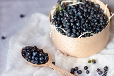 Yaban mersinleri ahşap kasede, yakın plan. Meyve suyu ve reçel için böğürtlen. Vejetaryen yemeği için taze toplanmış yaban mersini. Sağlık hayatı için organik vitaminler.