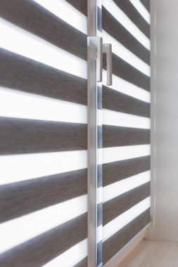 Modern bir iç mekanda şık çift tekerlekli zebraların yakın çekimi. Bu gölgeler esnek ışık kontrolü, mahremiyet ve mutfaklar, oturma odaları veya ev ofisleri için ideal şık bir tasarım sunuyor..