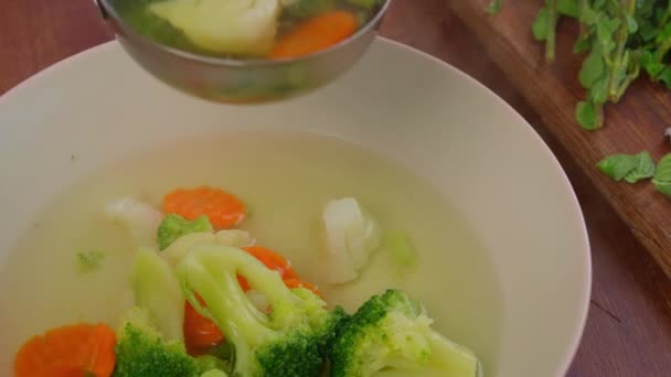 野菜の人参とスープで閉じます テーブルの上にブロッコリープレートベジタリアン食事 — ストック動画