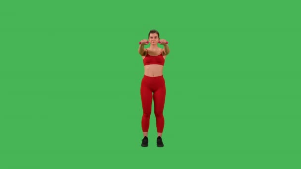 活跃的运动女性 身穿红色上衣 身穿运动腿的哑铃 在绿屏工作室里进行胳膊和肩膀的锻炼 — 图库视频影像