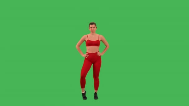 为腿和脚做热身运动的女人穿着红色的运动上衣和腿 被绿色屏风隔开了 — 图库视频影像