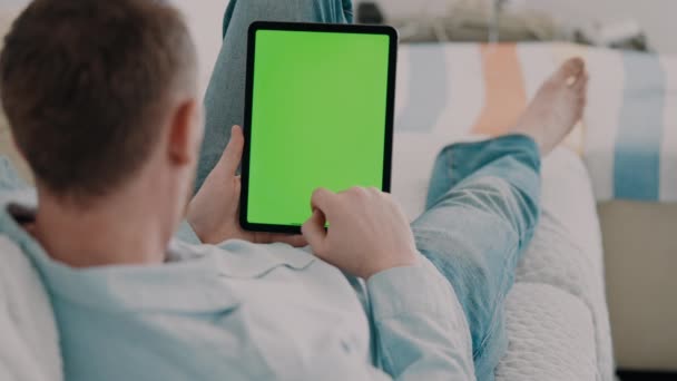 Guy Lying Couch Wearing Casual Shirt Using Digital Tablet Scrolling — Vídeo de Stock